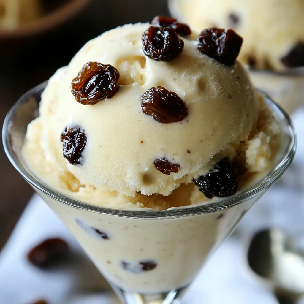 Un tazón de helado casero de ron y pasas, cremoso, con pasas visibles y servido en una mesa rústica.