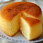 Bizcocho esponjoso recién horneado hecho en licuadora, servido sobre una tabla de madera.