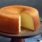 Bizcocho esponjoso recién horneado sobre una rejilla, con textura aireada y dorada.