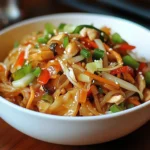 Plato de Chop Suey Chino casero con vegetales crujientes y tiras de pollo servido con arroz blanco