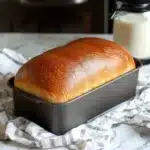 Pan integral recién horneado en molde rectangular, con corteza dorada y textura esponjosa