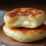 Pan de queso sin horno dorado y servido caliente sobre plato de madera
