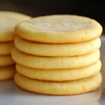 Galletas de limón caseras recién horneadas sobre una rejilla con textura suave y bordes dorados