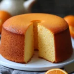 Queque de naranja esponjoso servido en rebanadas sobre una mesa rústica