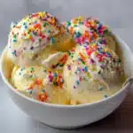 Helado de vainilla casero con chispas de colores servido en un tazón
