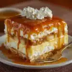 Corte del pastel bomba frío con capas de galletas, crema de vainilla y manzanas caramelizadas.