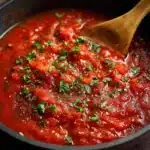 Salsa de tomate casera en sartén, cocinada con tomates frescos y cebolla