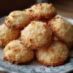 Galletas de coco caseras sobre una bandeja enfriándose, doradas y con textura crujiente